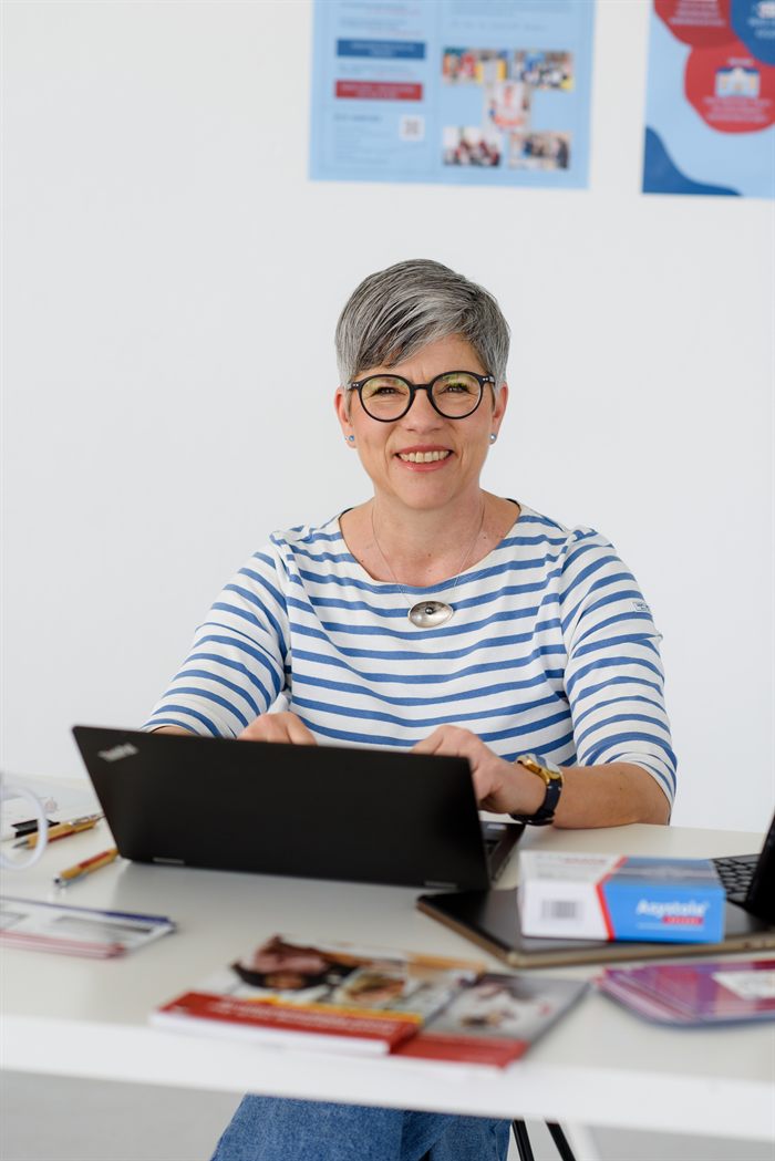 Tina Knoch an ihrem Arbeitsplatz, im Hintergrund QUESAP-Materialien